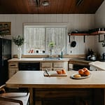 Como Organizar a Geladeira: Dicas Práticas para Manter os Alimentos Frescos e Evitar o Desperdício a kitchen with a table and a refrigerator