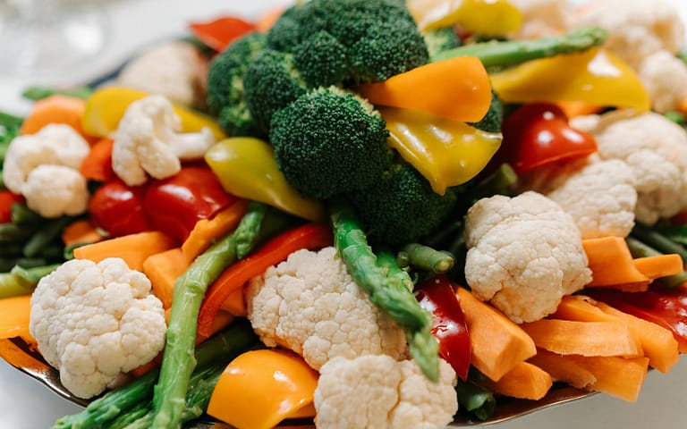 Quanto tempo cozinhar cada legume? Guia completo para não errar no ponto A vibrant assortment of fresh vegetables including broccoli, asparagus, and bell peppers.
